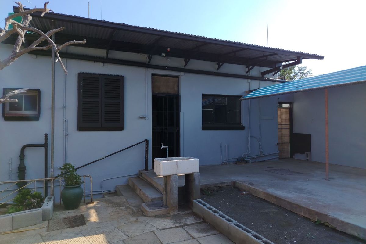 Rear exterior view of the property featuring a concrete patio area, an outdoor utility sink, and a covered lean-to structure.