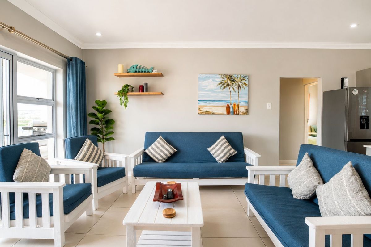 A bright and airy living room featuring neutral tiled flooring, recessed lighting, and large windows that provide ample natural light.