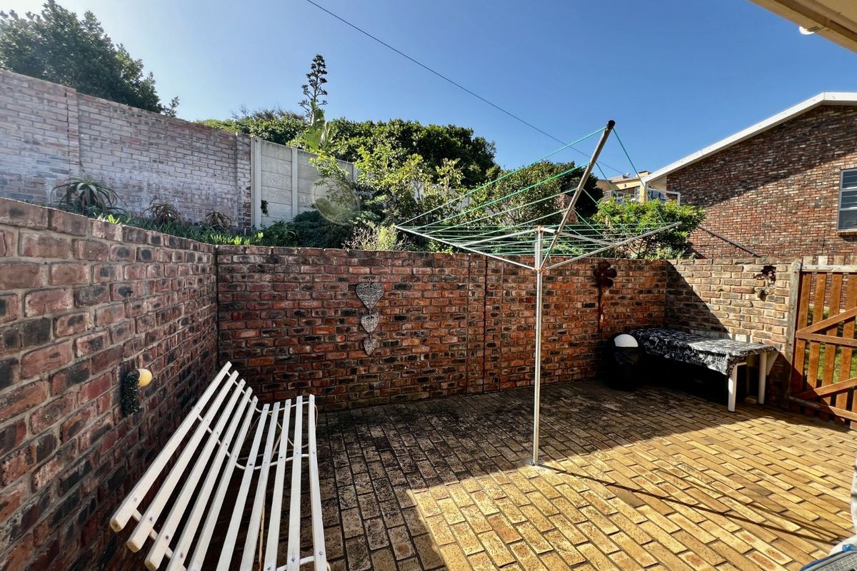 A private rear courtyard featuring exposed brick boundary walls and paved flooring, providing a functional outdoor space.
