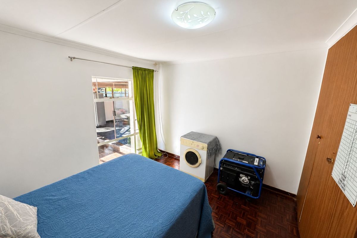 A bedroom featuring parquet flooring, a built-in wooden wardrobe, and direct access to an outdoor patio area.