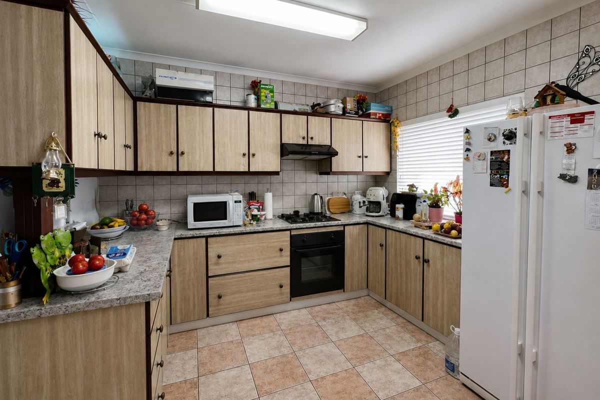 Functional kitchen featuring laminate cabinetry, tiled backsplash, built-in oven, gas hob, and extractor fan with tiled flooring.