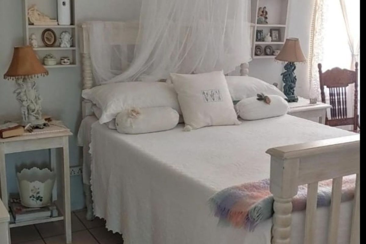 A cozy bedroom featuring built-in wall shelving units and tiled flooring, creating a classic and functional sleeping space.