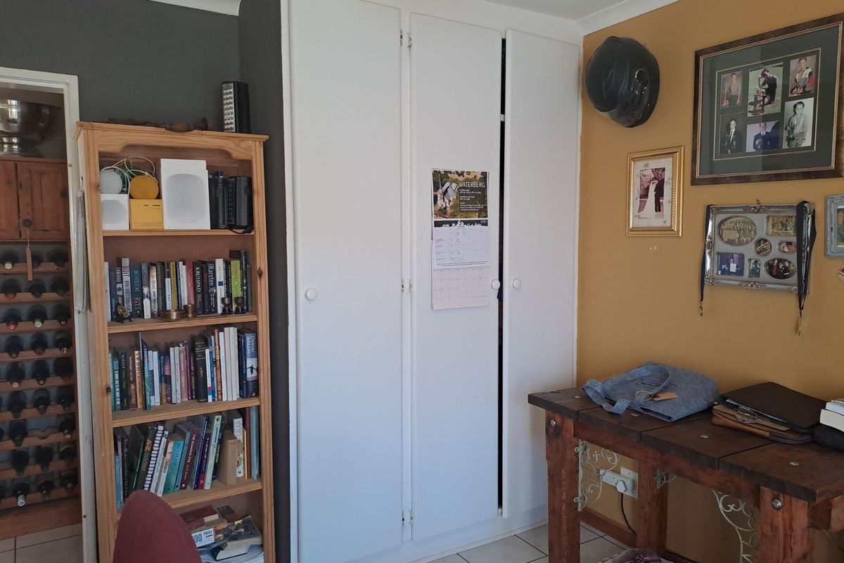 A functional interior space featuring built-in white storage cupboards and tiled flooring, providing practical storage solutions within the home.