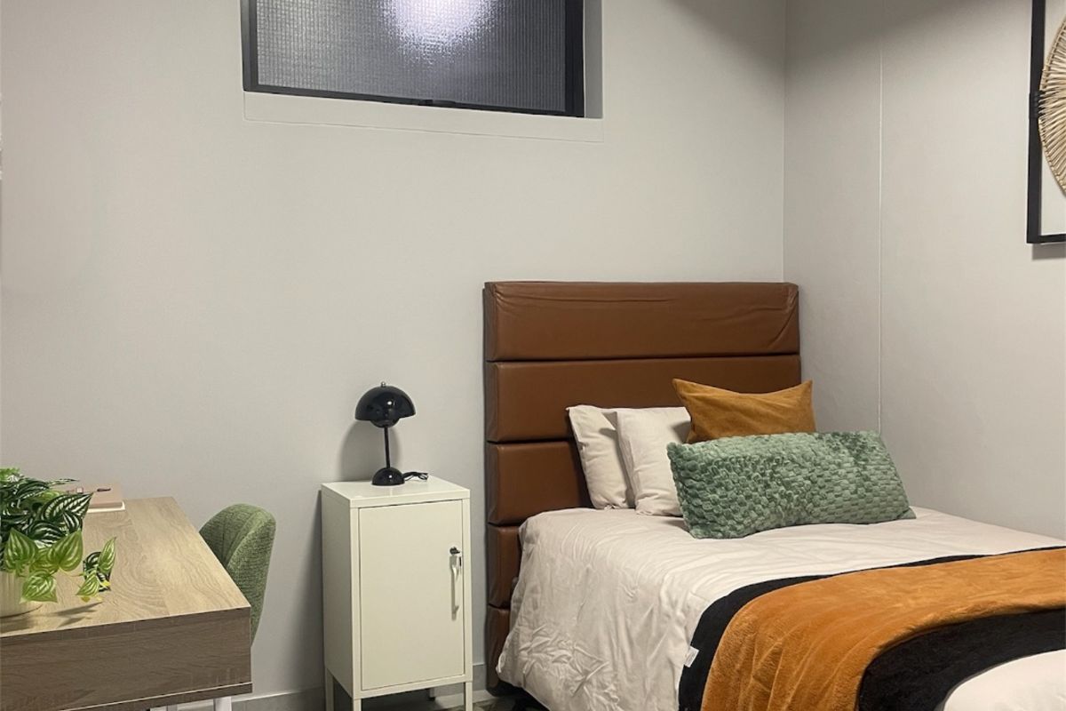 A modern bedroom featuring a high-set horizontal window, neutral wall finishes, and a clean, contemporary aesthetic.