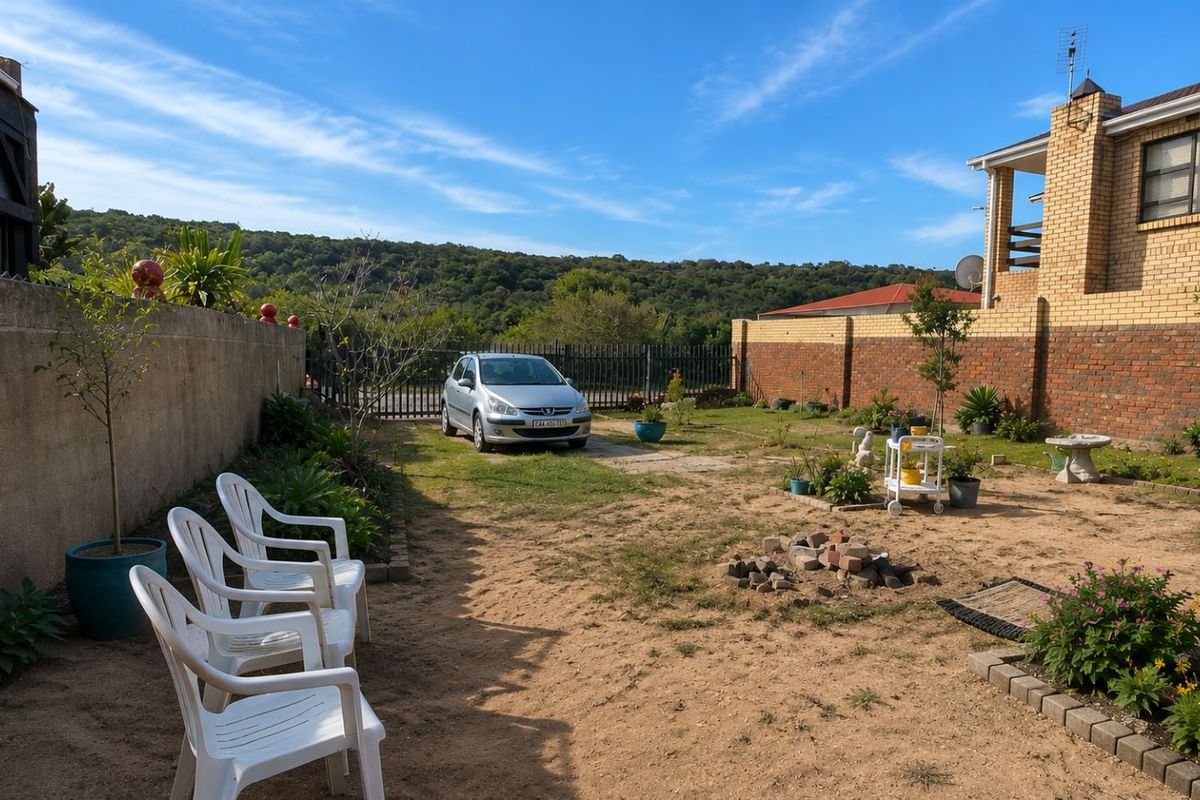 A spacious rear garden area featuring a brick boundary wall, established landscaping, and open space with potential for further outdoor development.