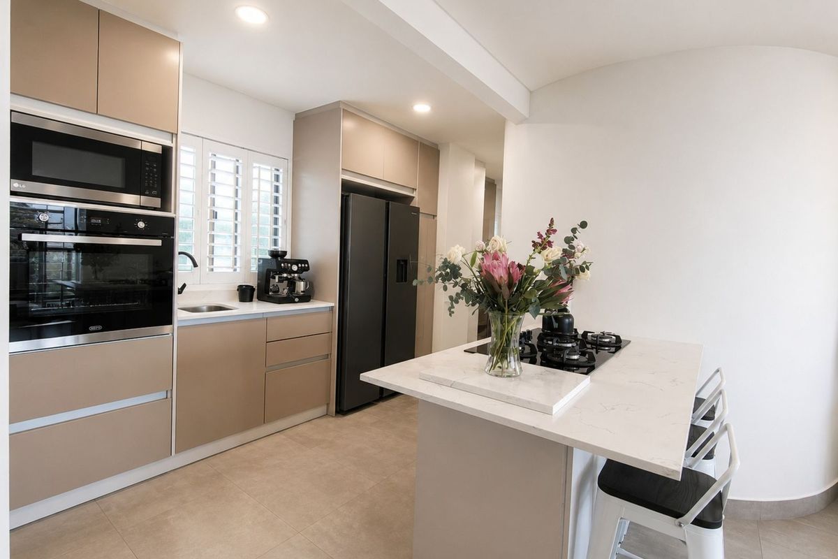 Modern kitchen featuring sleek cabinetry, built-in oven and microwave, stone countertops, and a central island with an integrated gas hob.