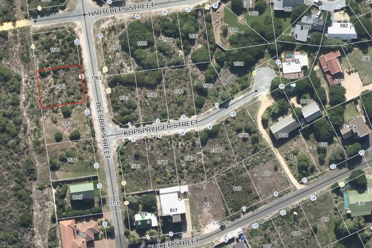 Aerial view of a vacant residential plot in a developed neighborhood, highlighting the property boundaries and surrounding street layout.