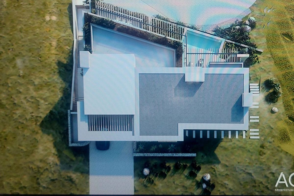 An aerial view of a modern residential property design featuring a flat roof, swimming pool, and landscaped outdoor areas.