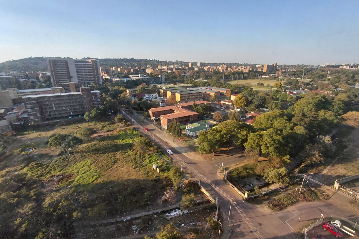 Elevated aerial view overlooking the surrounding urban neighborhood, streets, and green spaces.