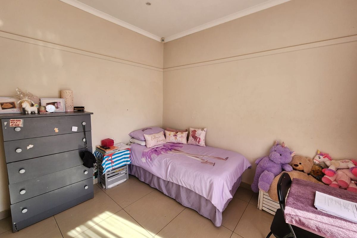 A functional bedroom featuring tiled flooring and neutral wall finishes, providing a comfortable and versatile space.