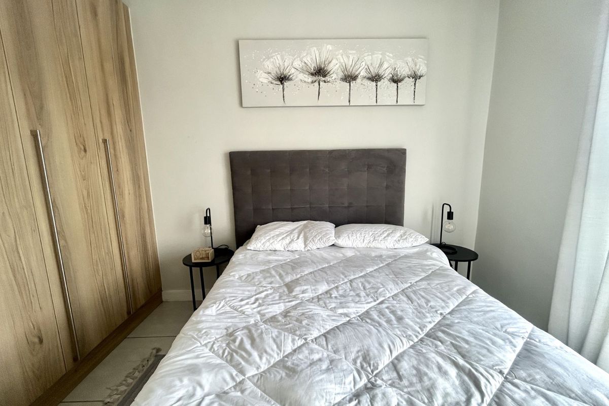 A well-maintained bedroom featuring built-in wooden cabinetry and neutral finishes, providing a clean and functional living space.