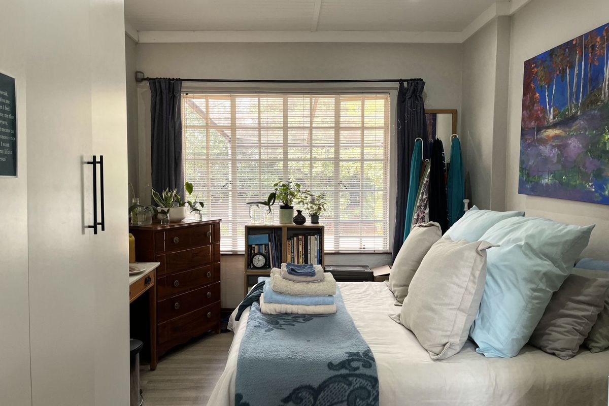 A well-maintained bedroom featuring recessed ceiling lighting, neutral wall finishes, and large windows with fitted blinds, providing a bright and comfortable living space.