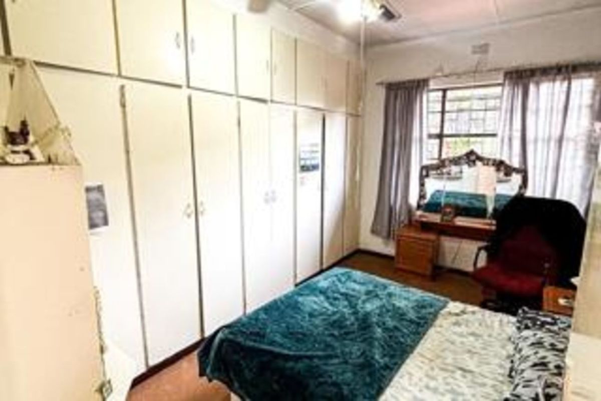 A bedroom featuring extensive floor-to-ceiling built-in cabinetry providing ample storage space, with a window allowing natural light into the room.