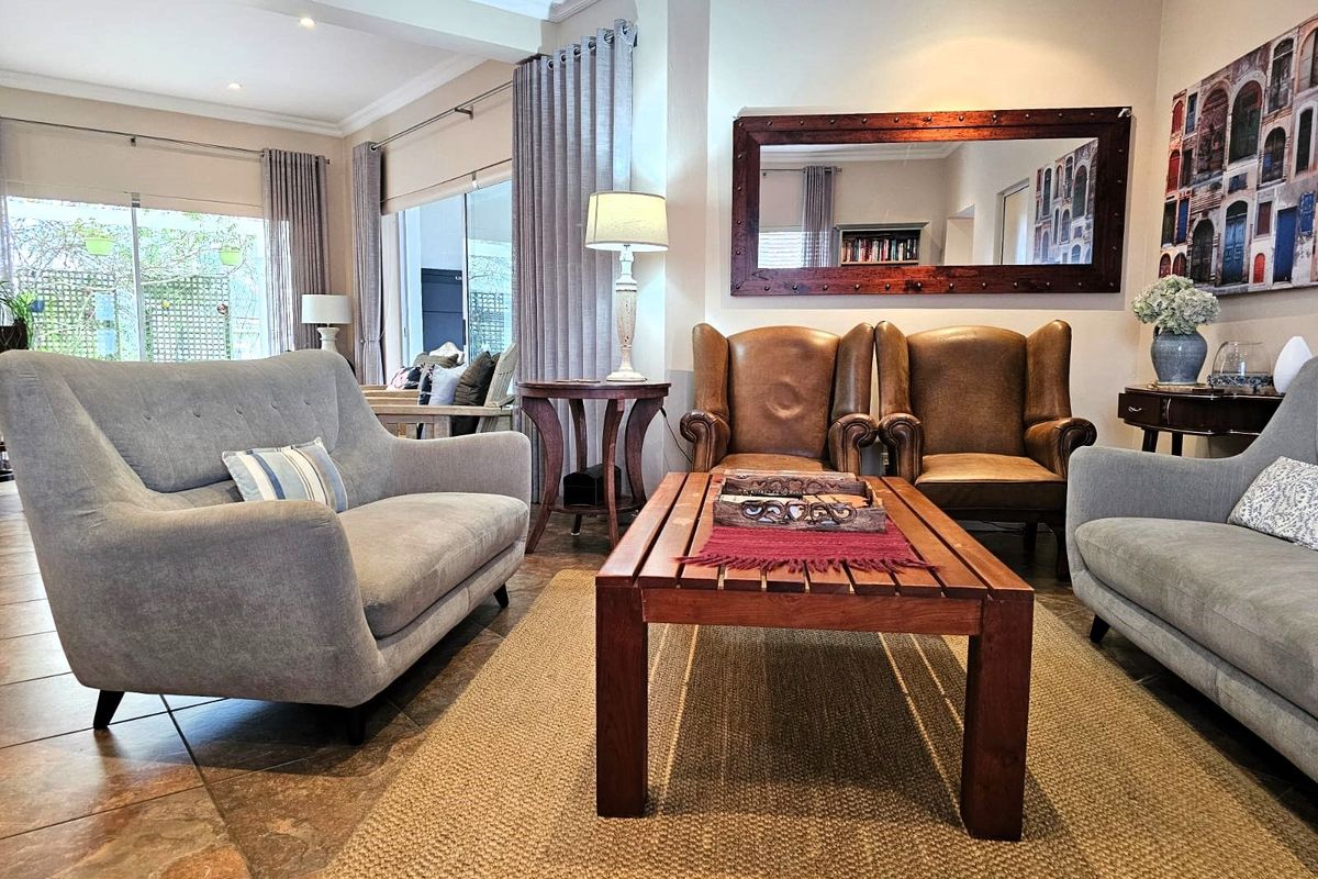 A comfortable living room featuring tiled flooring, recessed ceiling lighting, and large sliding glass doors providing access to the outdoor area.