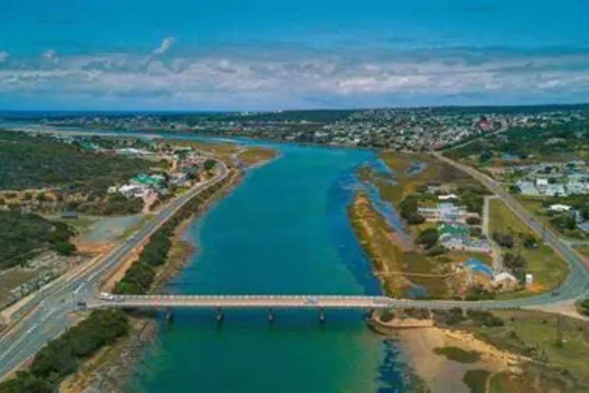 An aerial view of the coastal landscape, featuring a bridge crossing the river and surrounding residential development.
