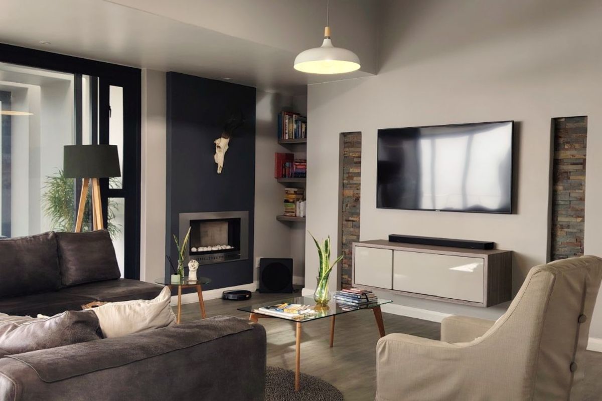 Modern living room featuring a built-in fireplace, stone-accented wall niches, floating media console, and large sliding glass doors leading to an outdoor area.