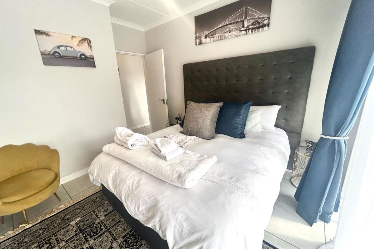 A well-maintained bedroom featuring neutral wall finishes, tiled flooring, and a built-in door frame, offering a clean and comfortable living space.
