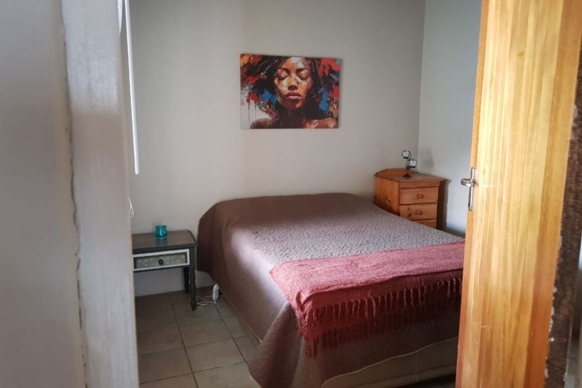 A bedroom featuring tiled flooring and a thatched roof ceiling, providing a rustic aesthetic.