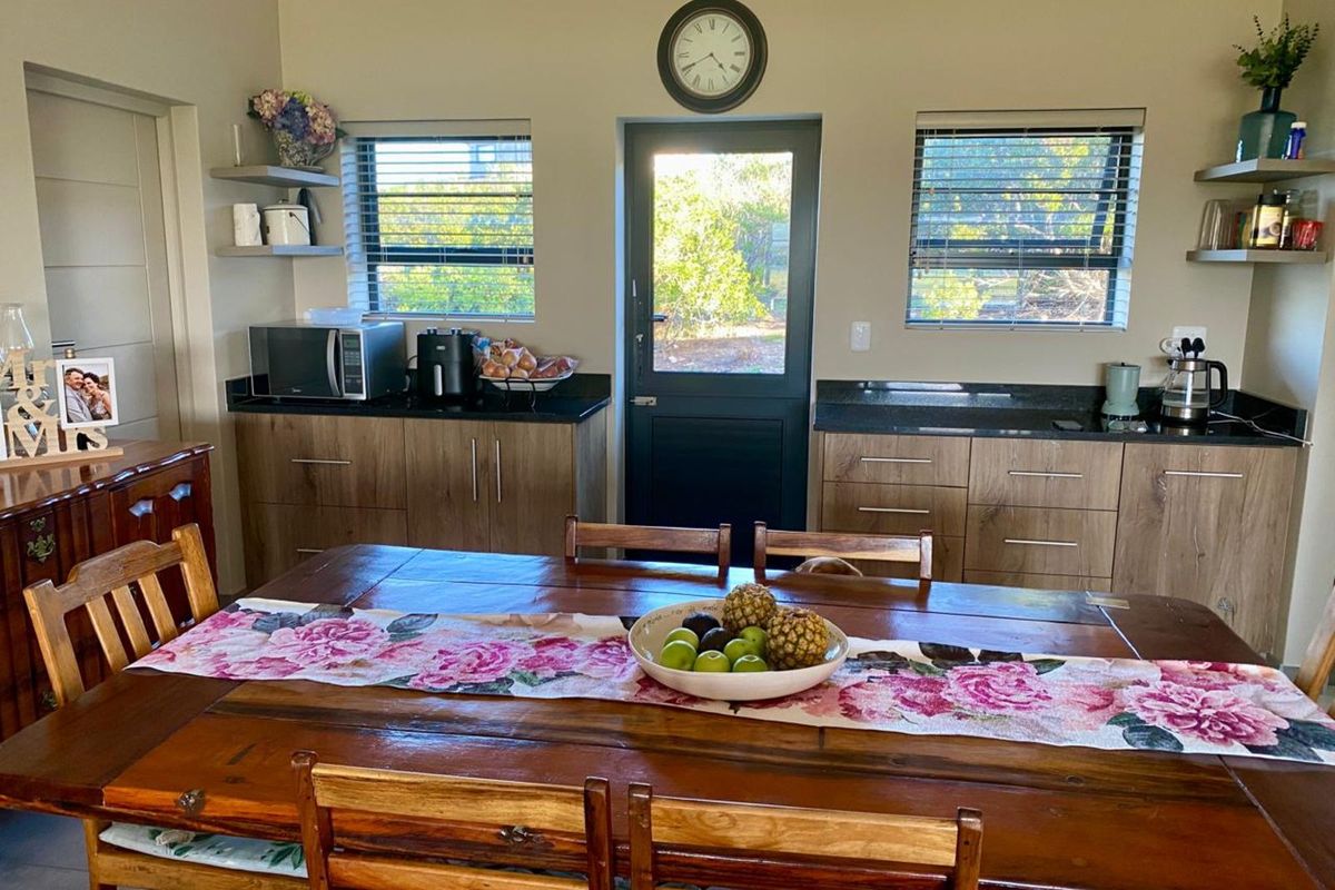 A functional kitchen area featuring wood-look cabinetry, dark granite countertops, and direct access to the exterior through a glass-paneled door.