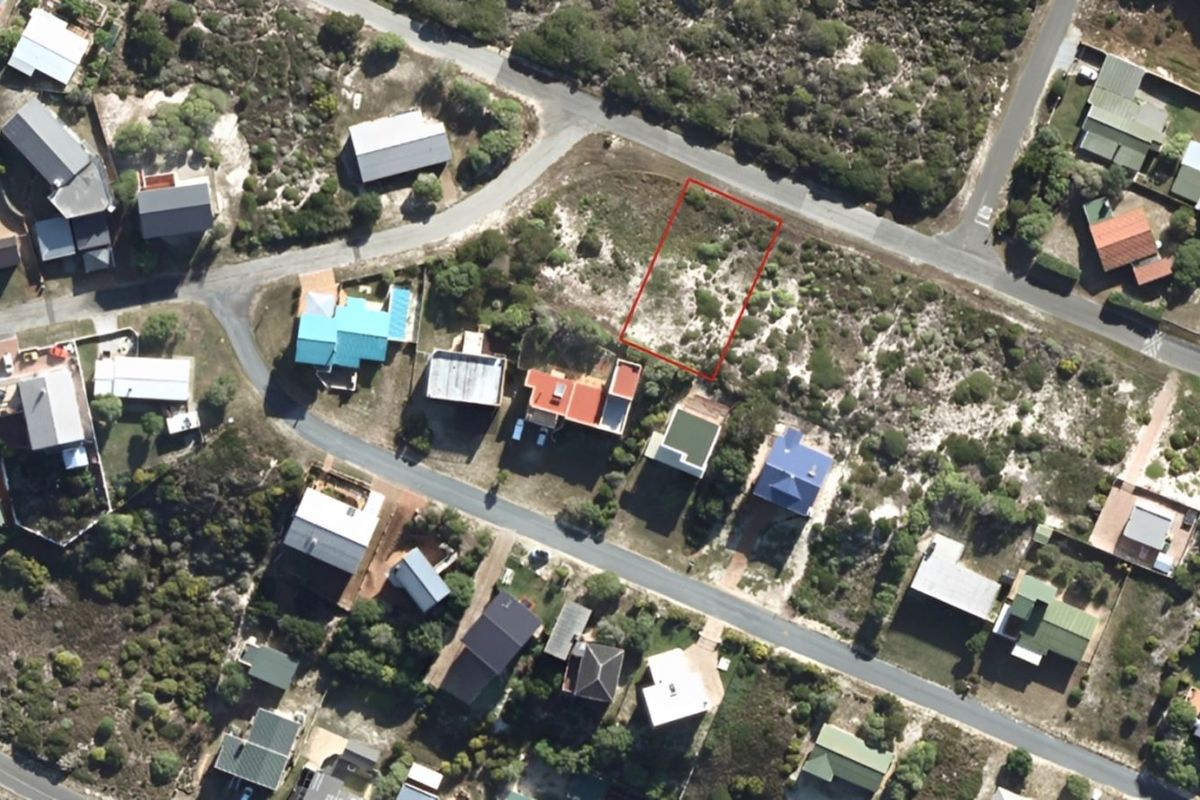 Aerial view of a vacant residential plot in a coastal neighborhood, highlighting the property boundaries and surrounding established homes.