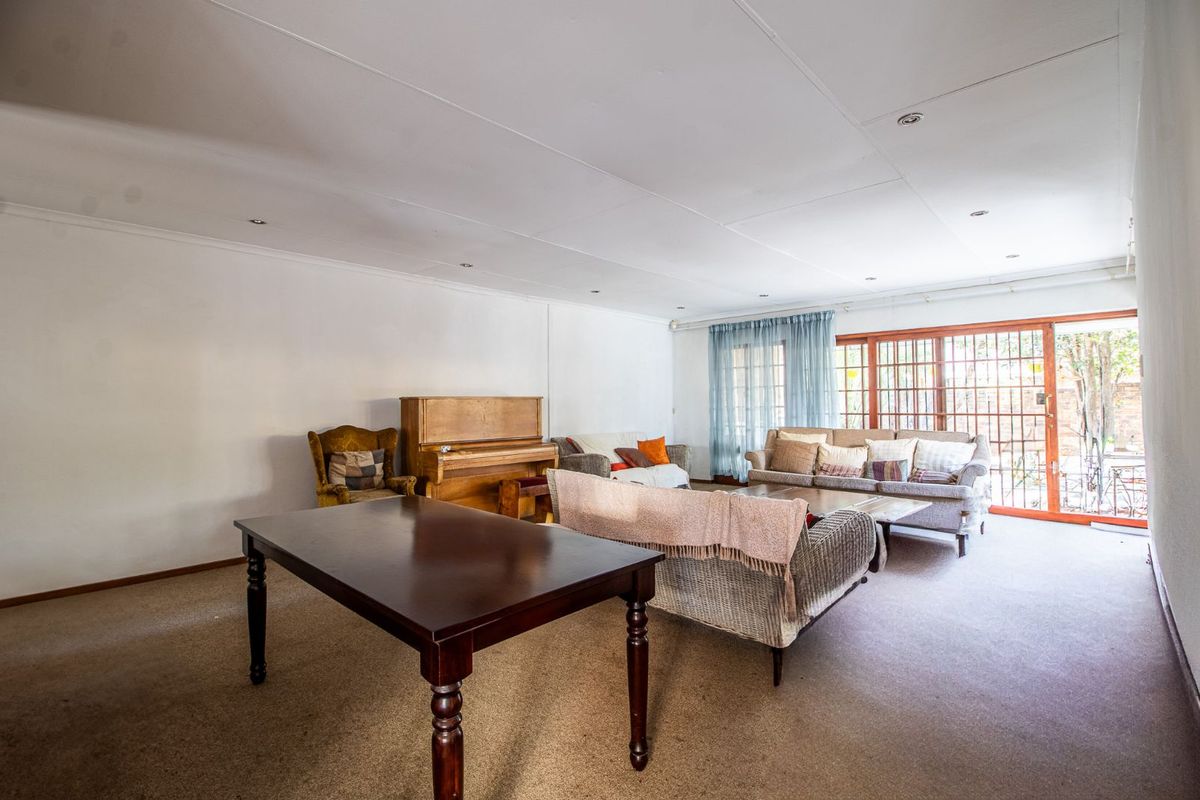 Spacious living area featuring recessed lighting and large sliding glass doors with security gates, providing access to the outdoor space.