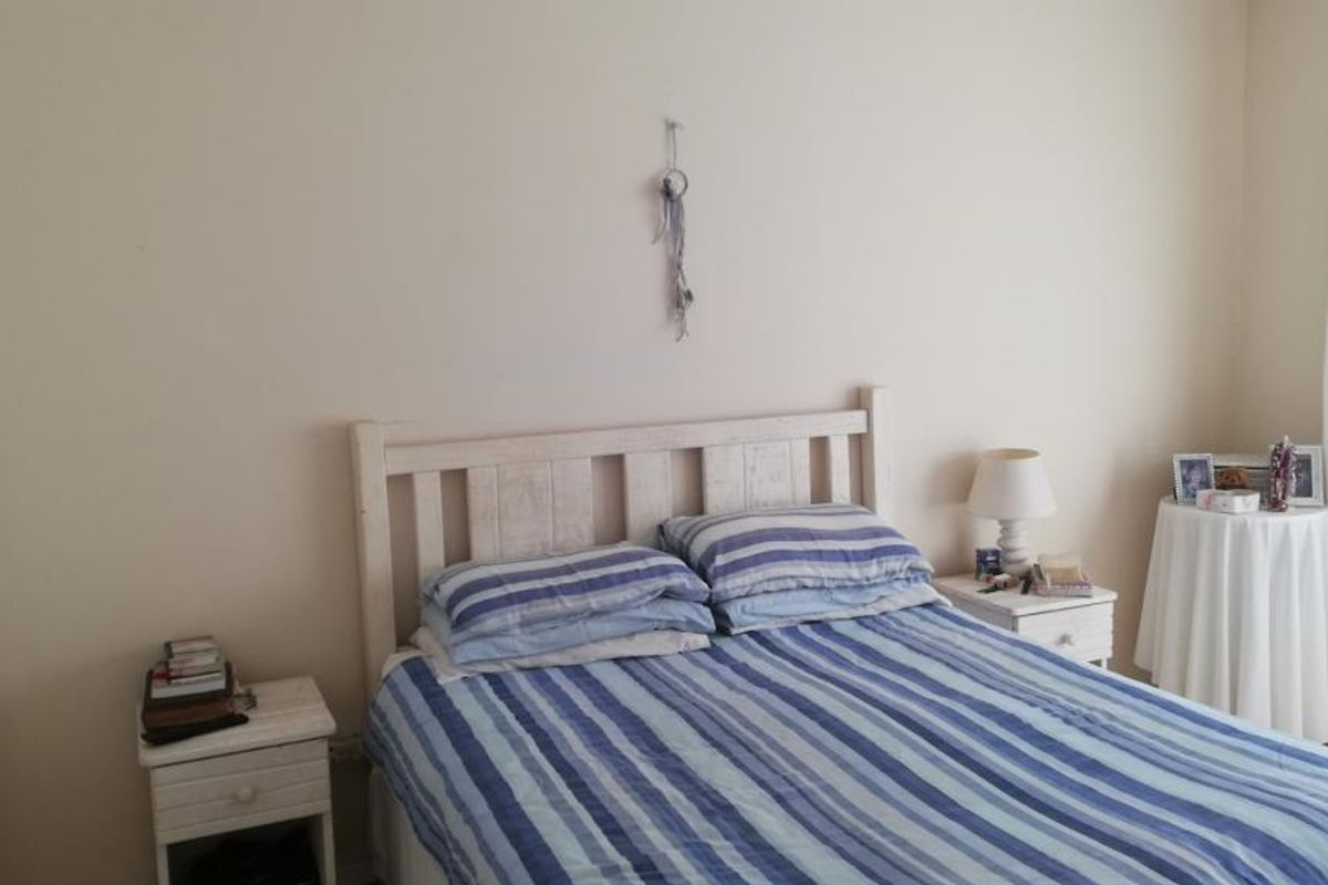 A functional bedroom featuring neutral wall finishes and a built-in cupboard, providing a comfortable and practical sleeping space.