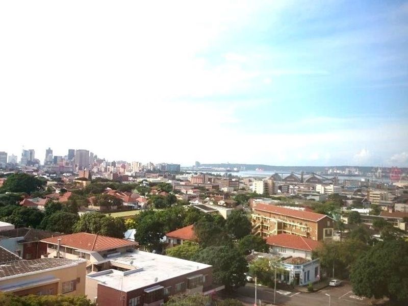 An elevated panoramic view overlooking the surrounding urban landscape, residential rooftops, and distant city skyline.