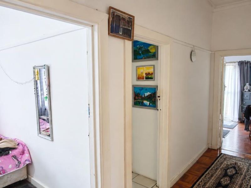 A functional hallway featuring parquet flooring and white-painted door frames, providing access to multiple rooms within the home.