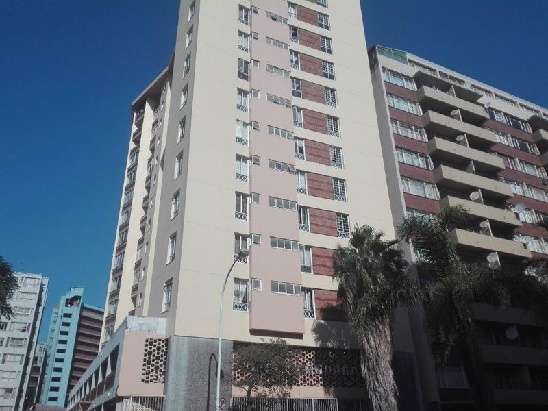 A view of the multi-story apartment building facade featuring balconies and exterior architectural detailing.