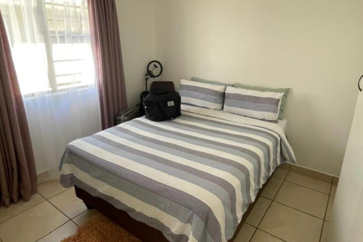 A functional bedroom featuring tiled flooring and built-in cupboards, providing essential storage space and a neutral foundation for personalization.