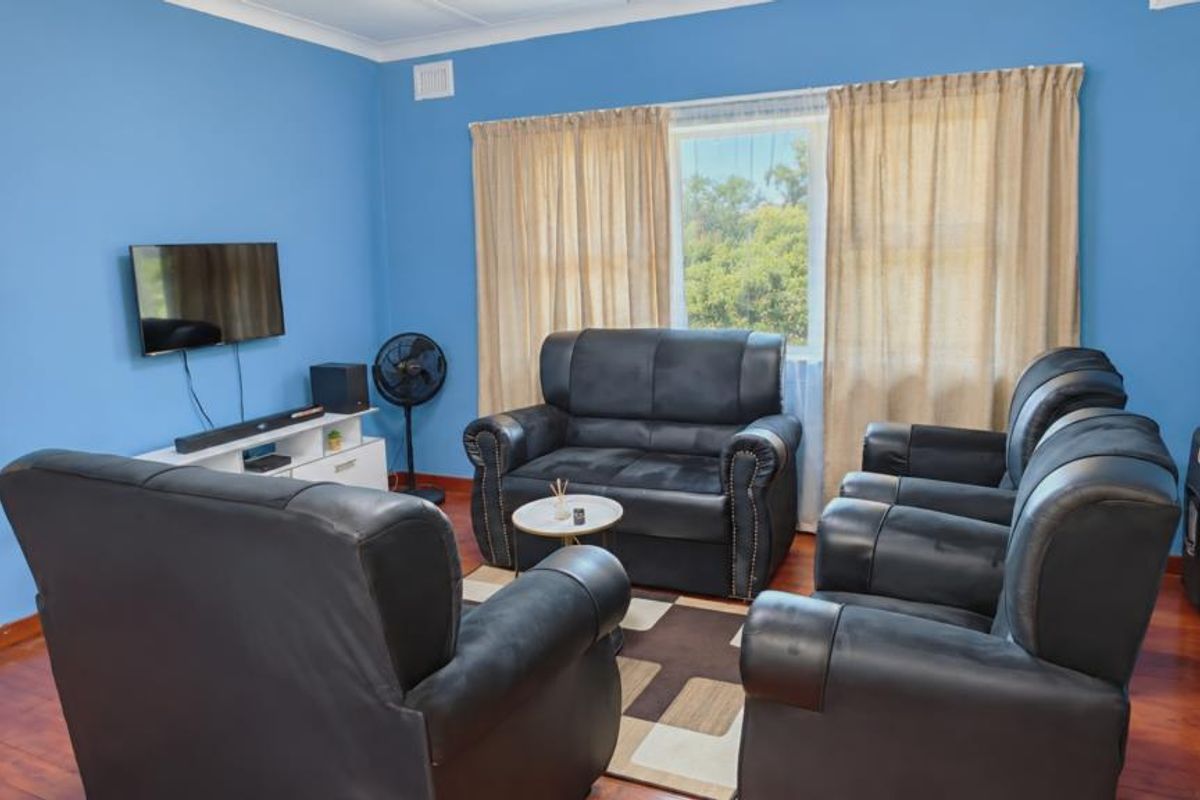 A living room featuring laminate flooring and coving, providing a functional space for relaxation.