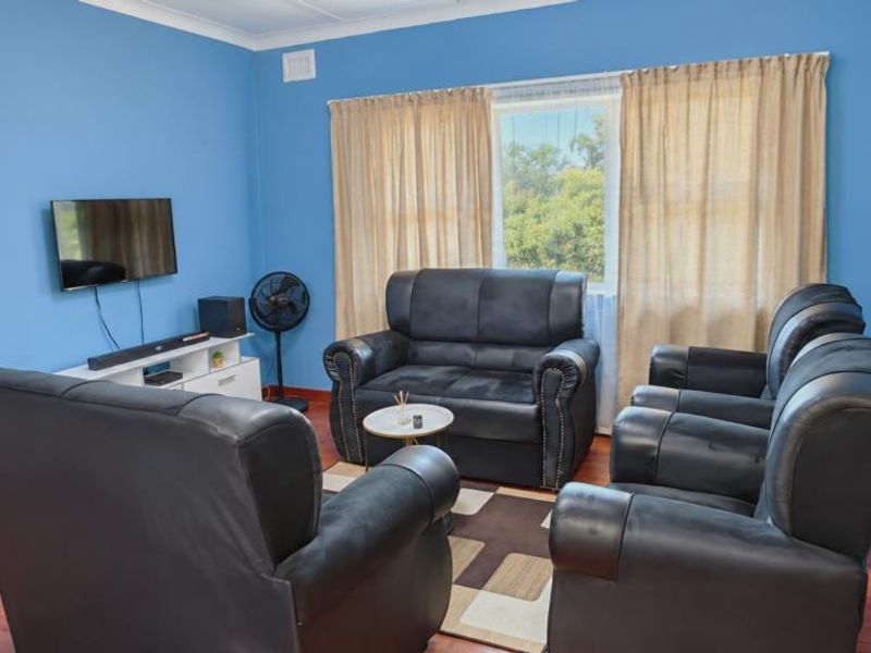 A living room featuring laminate flooring and coving, providing a functional space for relaxation.
