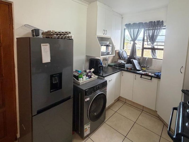 A clean, empty bedroom featuring neutral tiled flooring and ample built-in cupboard storage, providing a versatile space ready for personalization.