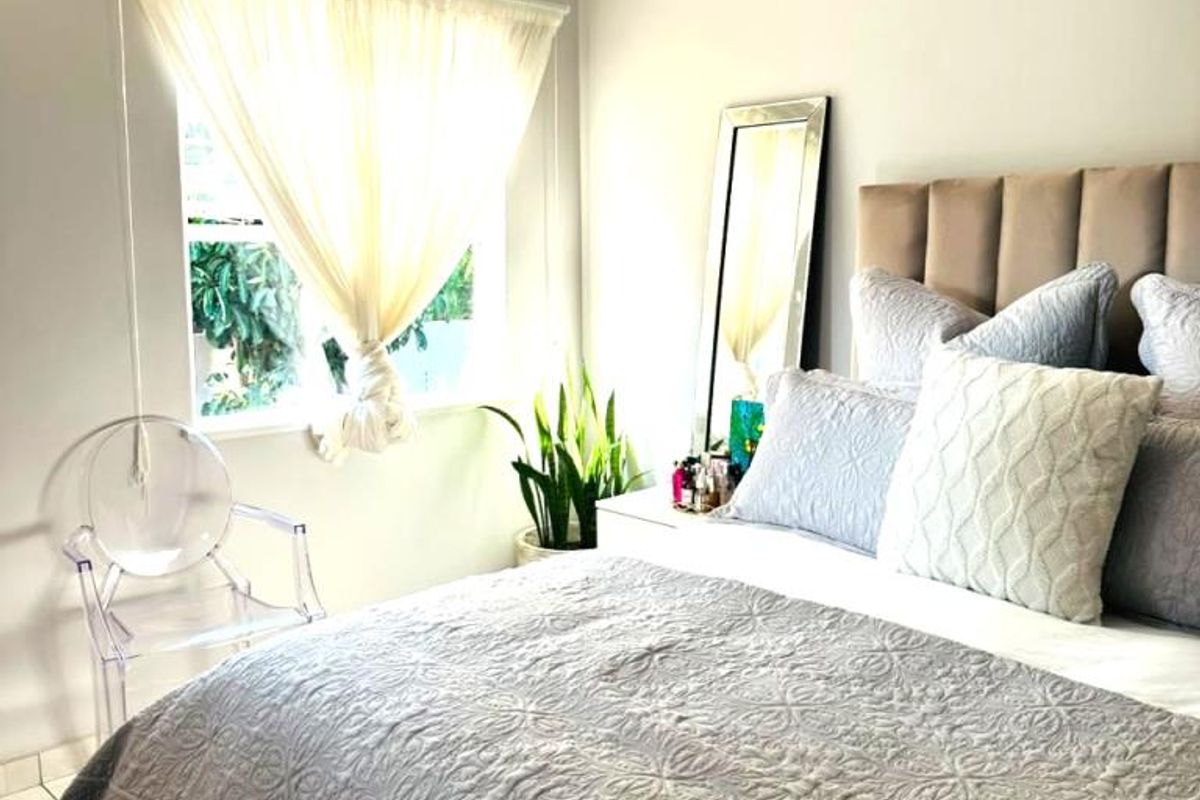 A well-maintained bedroom featuring tiled flooring, recessed lighting, and a ceiling fan, offering a comfortable and neutral living space.
