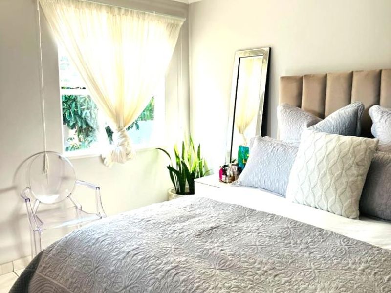 A well-maintained bedroom featuring tiled flooring, recessed lighting, and a ceiling fan, offering a comfortable and neutral living space.