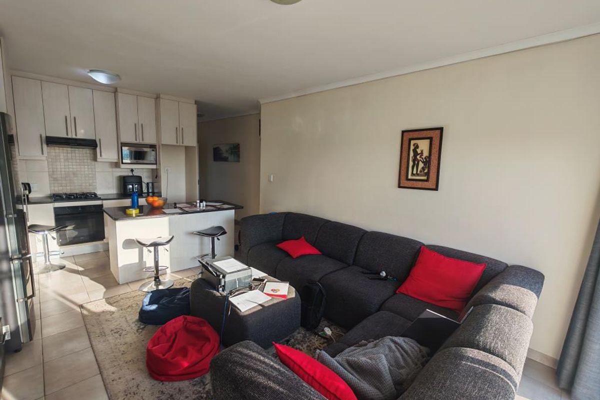 A living room area featuring tiled flooring and a sliding glass door providing access to the exterior.