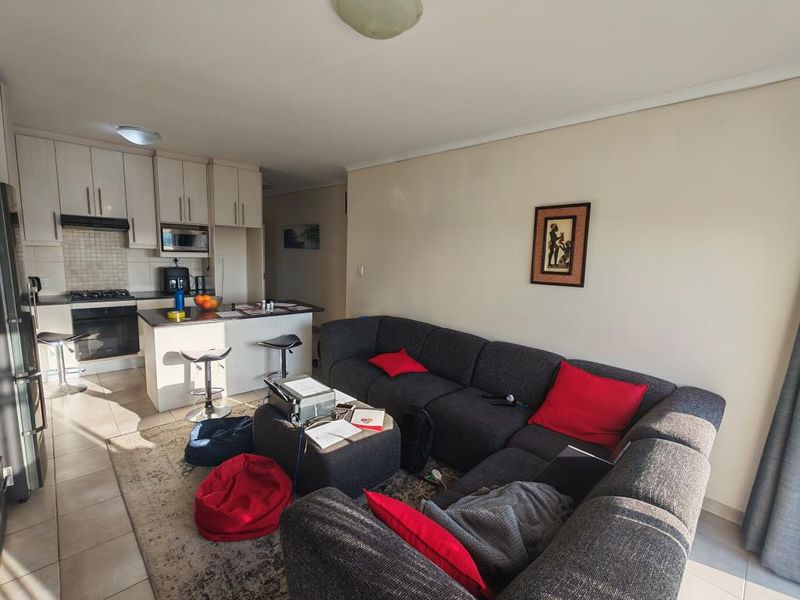 A living room area featuring tiled flooring and a sliding glass door providing access to the exterior.