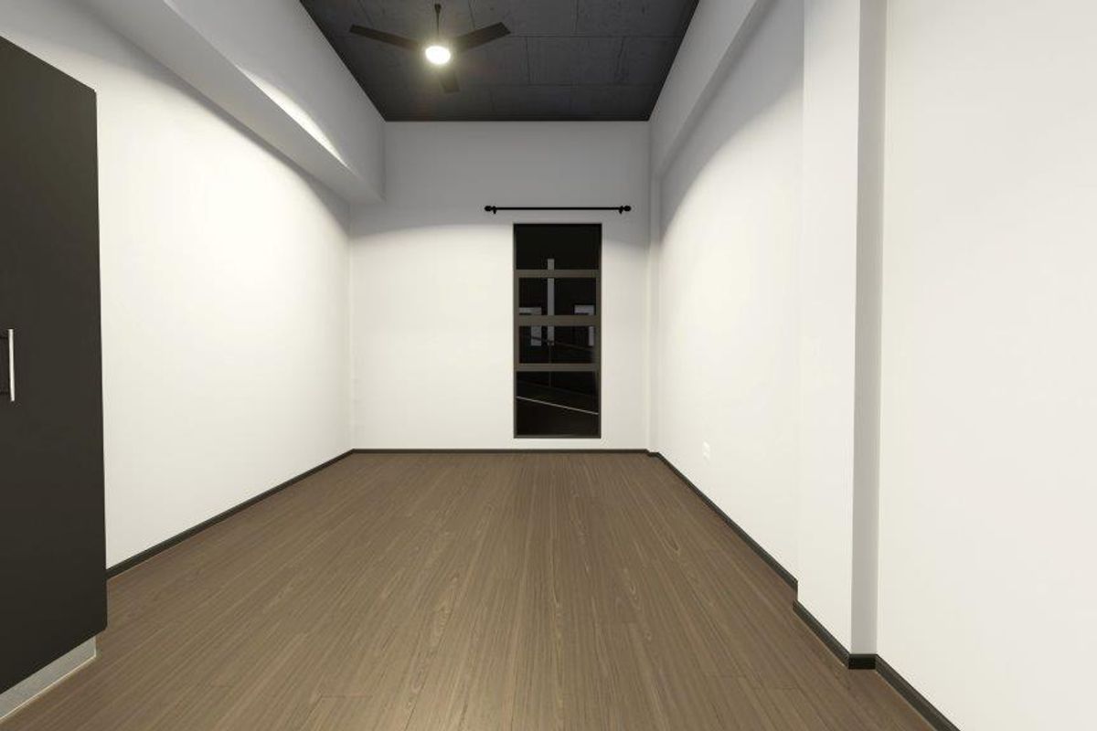 A clean, empty bedroom featuring modern laminate flooring, a built-in wardrobe, a dark ceiling finish, and a ceiling fan.