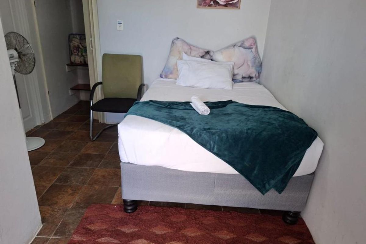 A compact bedroom featuring tiled flooring and an integrated storage closet, providing a functional sleeping space.