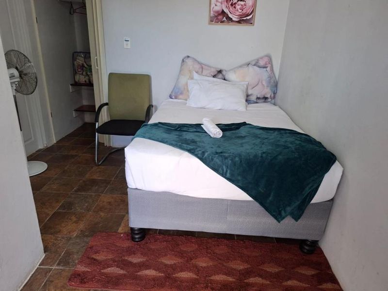 A compact bedroom featuring tiled flooring and an integrated storage closet, providing a functional sleeping space.