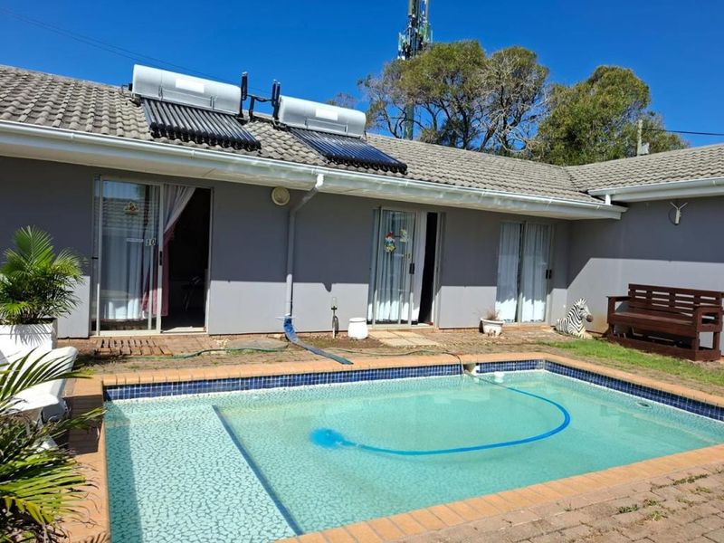Rear view of the apartment featuring a private swimming pool, solar water heating system, and sliding door access to the interior living spaces.