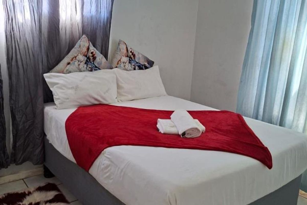A bedroom featuring tiled flooring and a wall-mounted air conditioning unit.