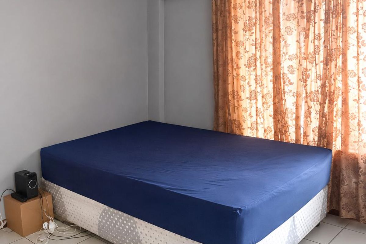 A bedroom featuring neutral grey walls and tiled flooring, providing a simple and functional space.