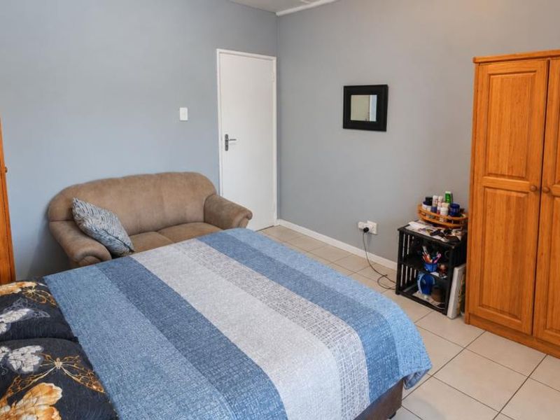 A functional bedroom featuring tiled flooring and neutral wall paint, providing a blank canvas for potential interior design updates.