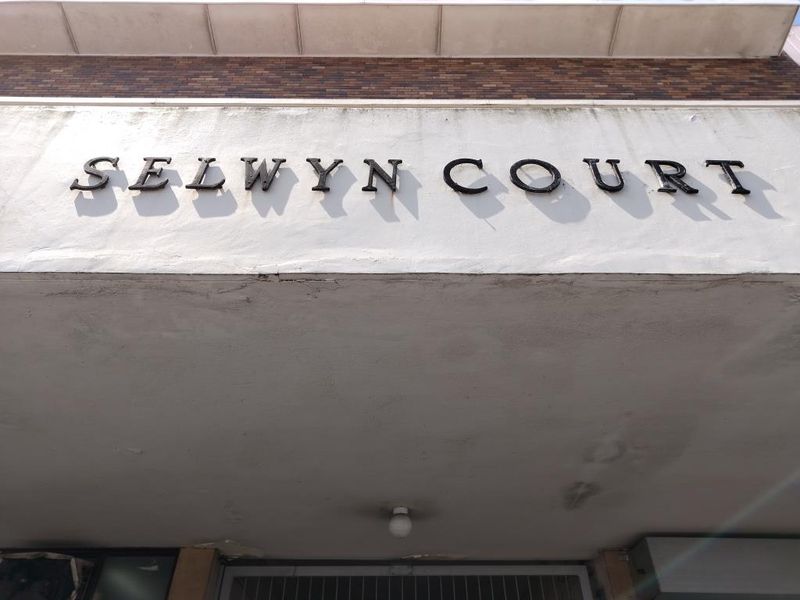 Exterior view of the Selwyn Court building entrance, featuring brick facade detailing and building signage.