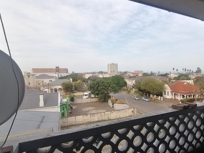 A balcony featuring a decorative breeze block balustrade, offering an elevated view over the surrounding neighbourhood and streetscape.