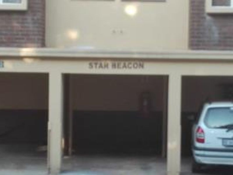 Front exterior view of the Star Beacon apartment complex featuring covered parking bays and brick facade detailing.