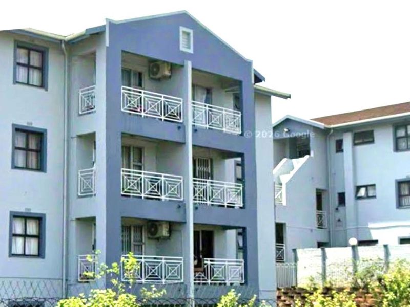 Exterior view of a multi-story apartment building featuring private balconies with metal railings and external air conditioning units.