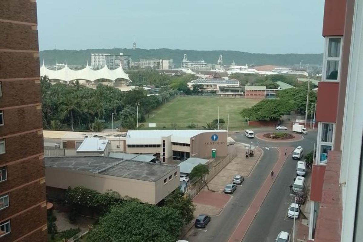 An elevated view overlooking the surrounding neighbourhood, street, and local infrastructure from the apartment building.