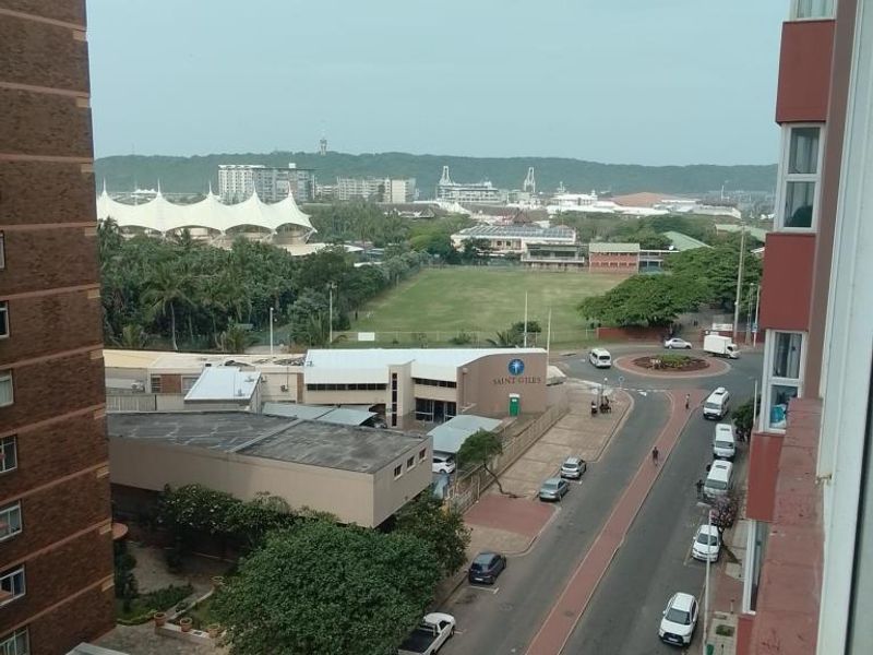 An elevated view overlooking the surrounding neighbourhood, street, and local infrastructure from the apartment building.